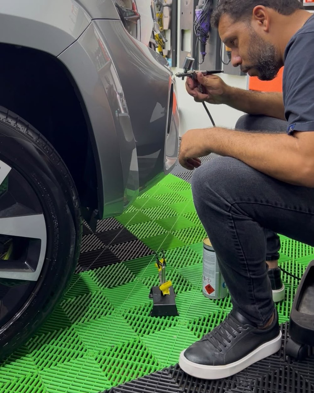 Boca Marcolino executando reparo com aerógrafo na lateral de um veículo